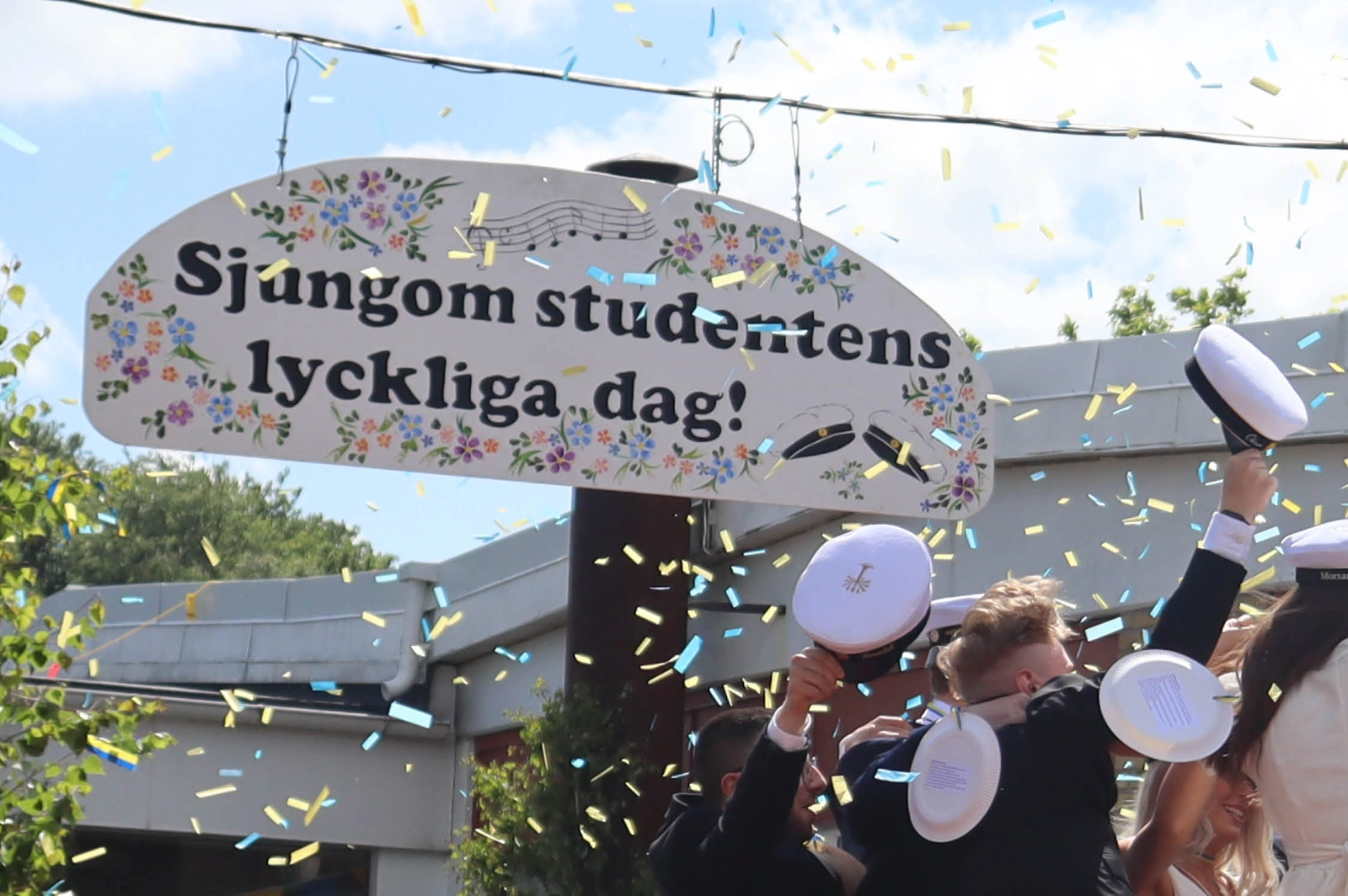 Studenter som kastar upp sina vita studentmössor