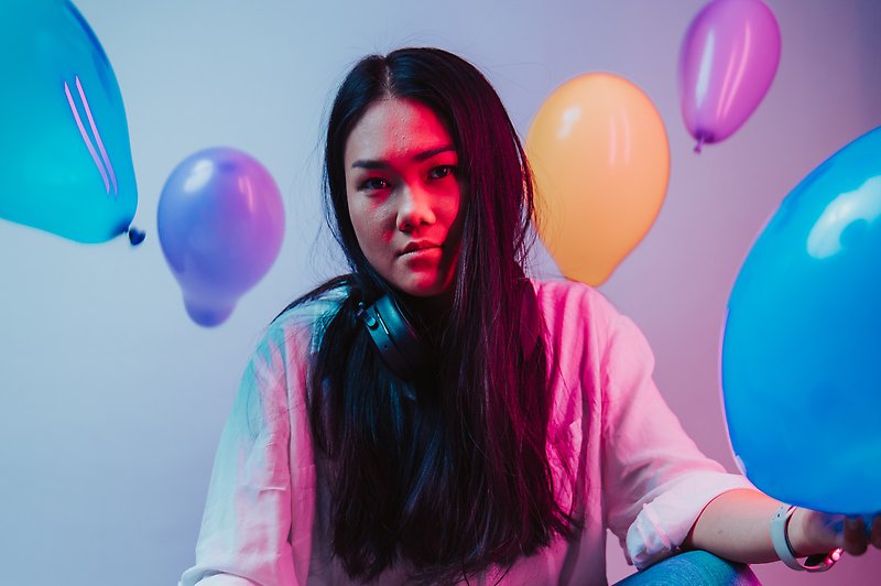 En kvinna med bland färgglada ballonger